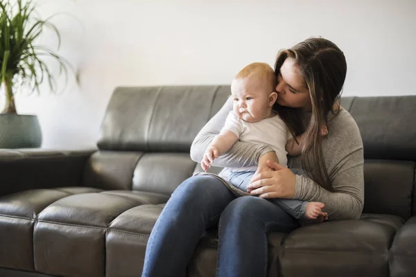 Mère avec bébé fille sur canapé à la maison — Photo