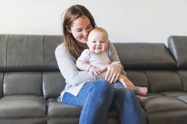 Mère avec bébé fille sur canapé à la maison — Photo