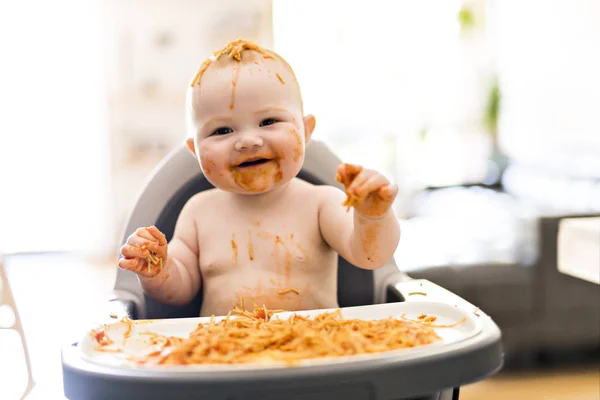 Pequeña niña comiendo su cena de espaguetis y haciendo un desastre — Foto de Stock