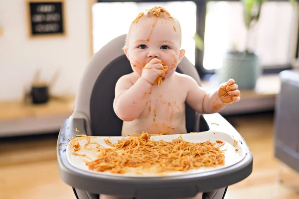 Pequeña niña comiendo su cena de espaguetis y haciendo un desastre — Foto de Stock