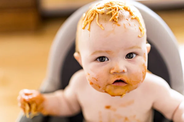 Pequeña niña comiendo su cena de espaguetis y haciendo un desastre — Foto de Stock