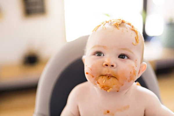 Pequeña niña comiendo su cena de espaguetis y haciendo un desastre — Foto de Stock