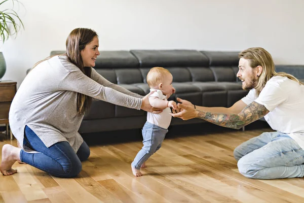 Aide parentale La petite fille fait ses premiers pas à la maison — Photo