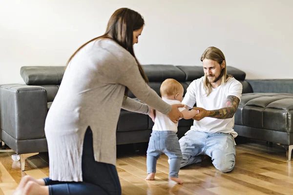 Aide parentale La petite fille fait ses premiers pas à la maison — Photo