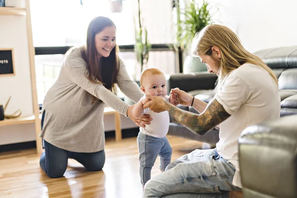 Aide parentale La petite fille fait ses premiers pas à la maison — Photo