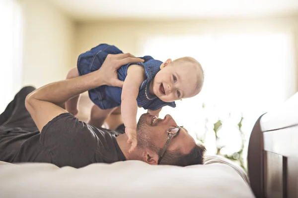 Padre jugando con su bebé en el dormitorio — Foto de Stock