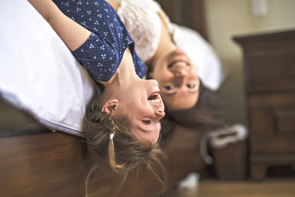 Mother playing with her baby in the bedroom upside down — Stock Photo, Image