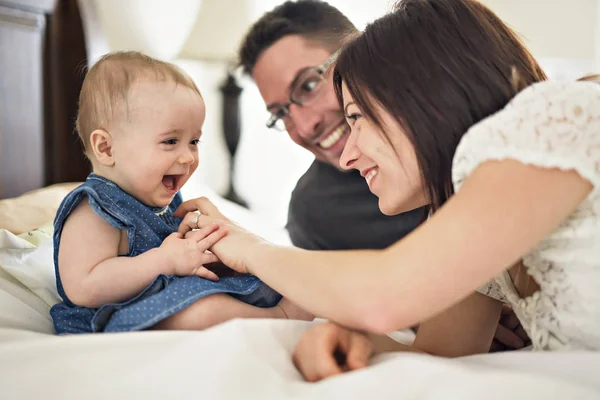Счастливая семья мать, отец и ребенок дома в постели — стоковое фото