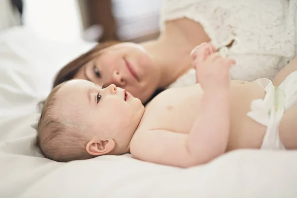 Madre jugando con su bebé en el dormitorio — Foto de Stock