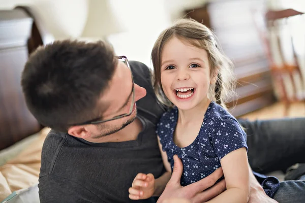 Vader en zijn dochter kind meisje spelen op bed — Stockfoto
