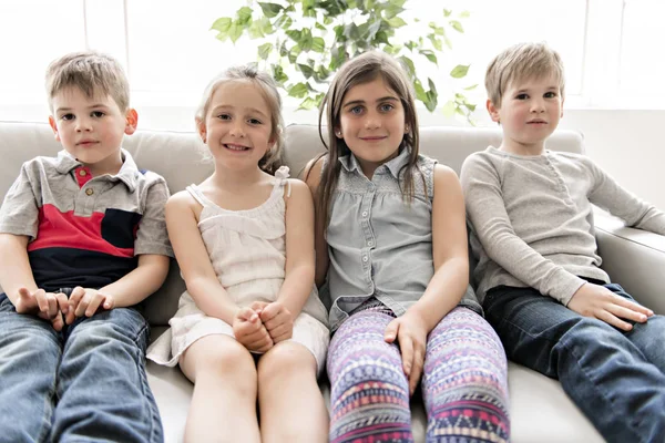 Groep van jonge vrienden samen op de bank tv te luisteren — Stockfoto