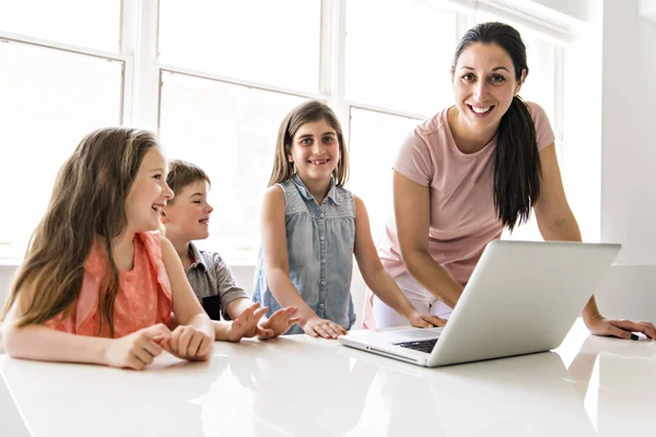 Leraar met een groep schoolkinderen met laptop op de voorkant — Stockfoto