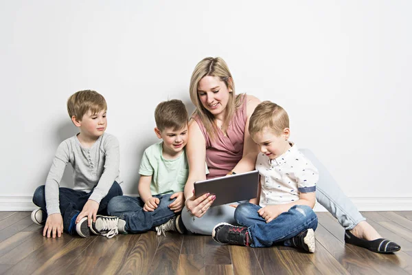 Ragazze e sua madre sono seduti sul pavimento, utilizzando un tablet digitale — Foto Stock