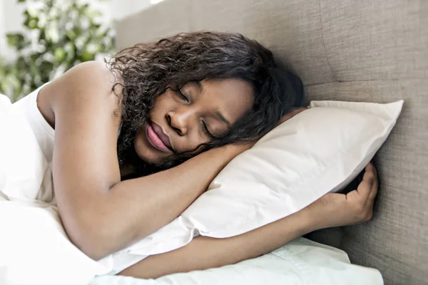 Mulher negra bonita em uma cama branca dormir — Fotografia de Stock