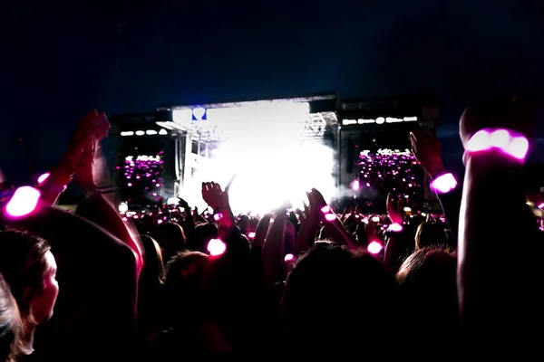 Silhuetas de multidão de concerto na frente de luzes de palco brilhantes. — Fotografia de Stock