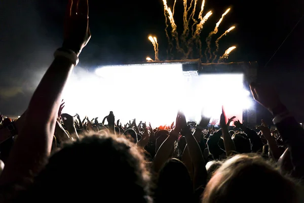 Silhuetas de multidão de concerto na frente de luzes de palco brilhantes. — Fotografia de Stock