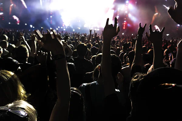 Siluetas de la multitud de conciertos frente a luces de escenario brillantes. — Foto de Stock