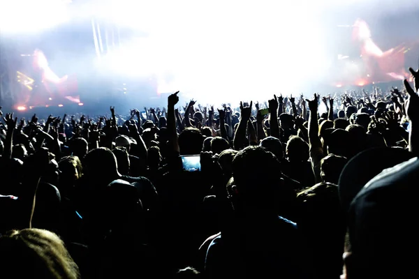 Siluetas de la multitud de conciertos frente a luces de escenario brillantes. —  Fotos de Stock