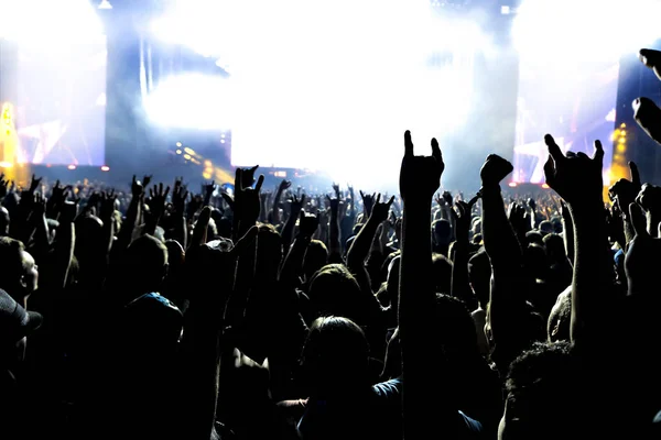 Silhuetas de multidão de concerto na frente de luzes de palco brilhantes. — Fotografia de Stock