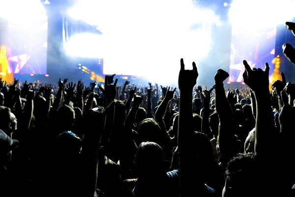 Silhuetas de multidão de concerto na frente de luzes de palco brilhantes. — Fotografia de Stock