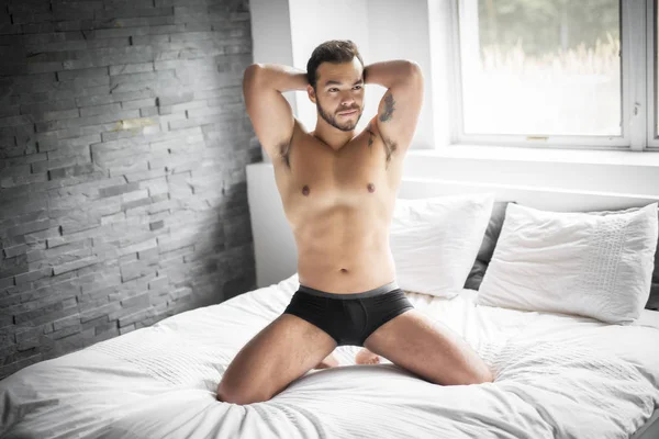 A young mexican man shirtless in white bed — Stock Photo, Image
