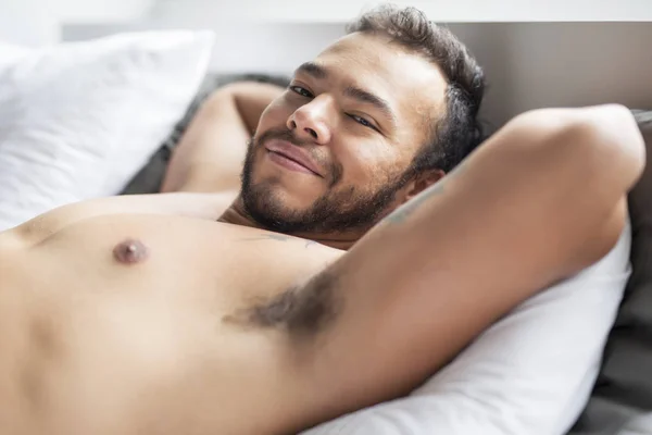 Un giovane messicano senza maglietta nel letto bianco — Foto Stock