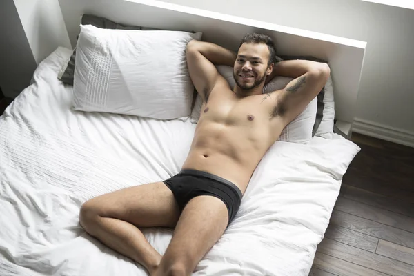 Un jeune mexicain torse nu dans un lit blanc — Photo