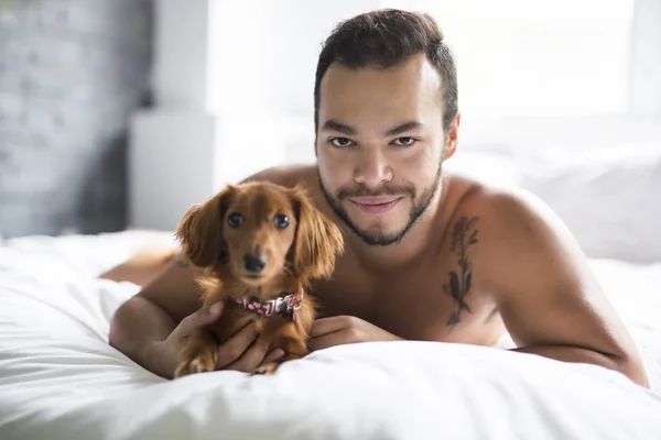 Homme couché sur le lit avec le chien — Photo