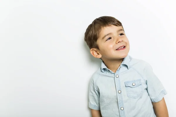 Menino se divertindo no estúdio cinza fundo — Fotografia de Stock