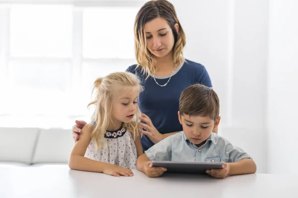 Urocza brat i siostra dziecko za pomocą tabletu z matka — Zdjęcie stockowe