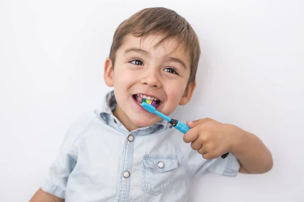 Smiley jongen reinigt een tanden geïsoleerd op een grijze achtergrond — Stockfoto