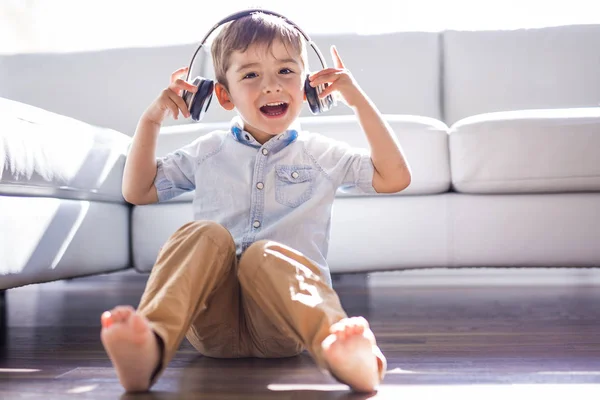 Felice bambina ascoltando musica vicino al divano soggiorno — Foto Stock