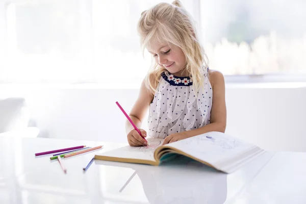 Маленька дівчинка малює на кухонному столі — стокове фото