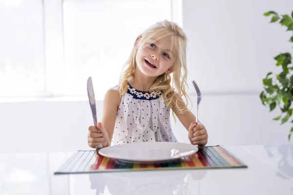 Little girl holding fork empty plate ready for food. — Stock Photo, Image