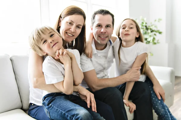 Een gezin van vier plezier op de Bank thuis — Stockfoto