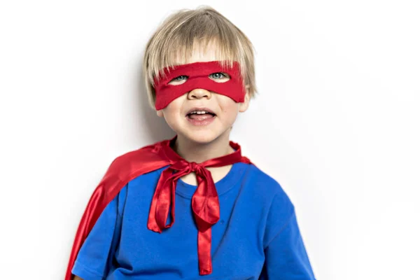 Ein blonder Junge Superheld in einem roten Mantel isoliert auf weißem Hintergrund — Stockfoto