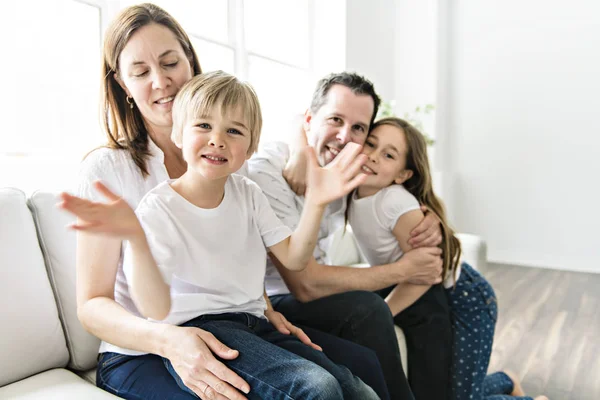 Uma família de quatro se divertindo no sofá em casa — Fotografia de Stock