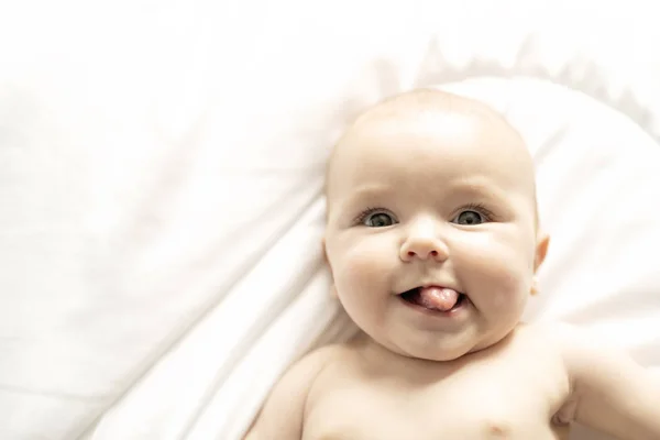 A Cute baby girl on a white bed at home — Stock Photo, Image