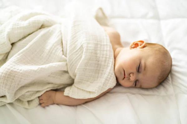4-месячный ребенок спит на белой кровати дома — стоковое фото
