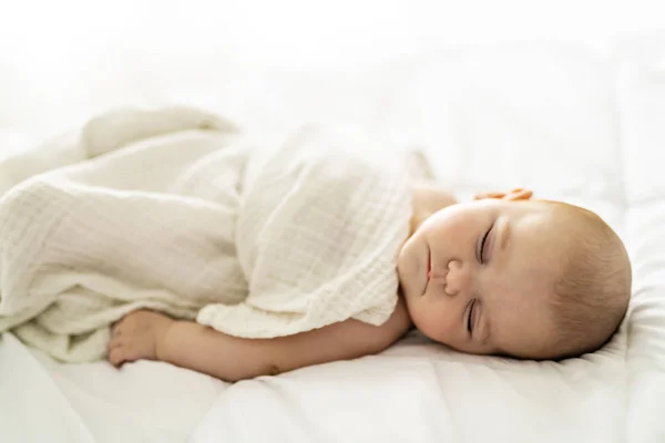 Um bebê de 4 meses dormindo em uma cama branca em casa — Fotografia de Stock
