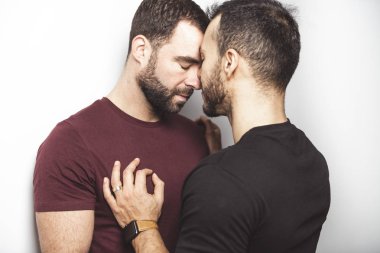 Young homosexuals gay couple love each other on a white background. clipart