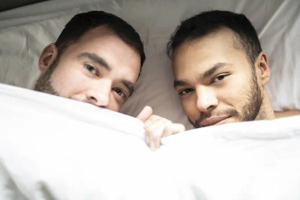 Un beau gay les hommes couple sur lit ensemble sous l 'couvercle — Photo