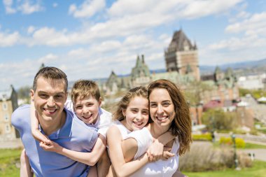 family in summer season in front of Chateau frontenac Quebec clipart