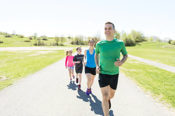 Parents with children sport running together outside — Stock Photo, Image