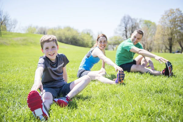 Parents with children sstretching together outside — Stock Photo, Image