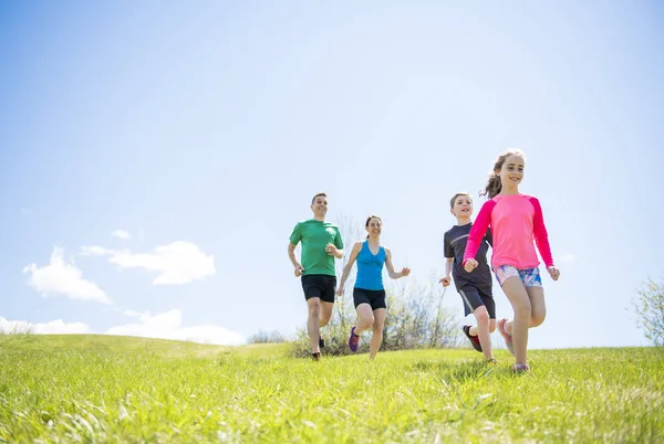 Parents with children sport running together outside — Stock Photo, Image