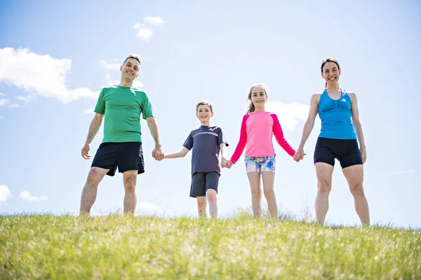 Pais com crianças esporte correndo juntos fora — Fotografia de Stock