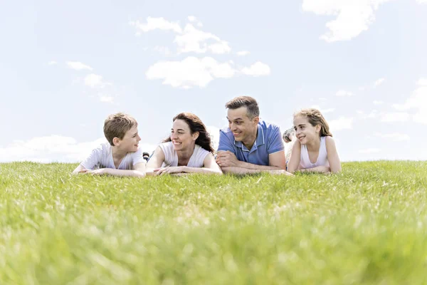Vierköpfige Familie im Freien auf einem Feld mit Spaß Stockbild