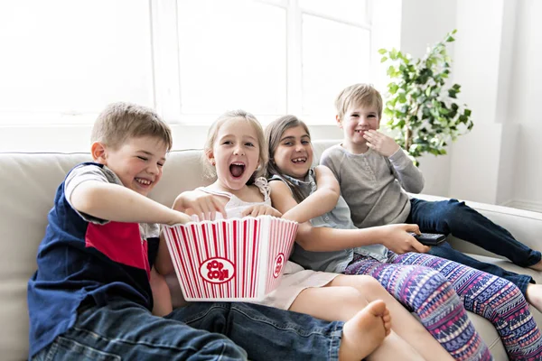 ソファで一緒にポップコーンを食べる子グループ — ストック写真