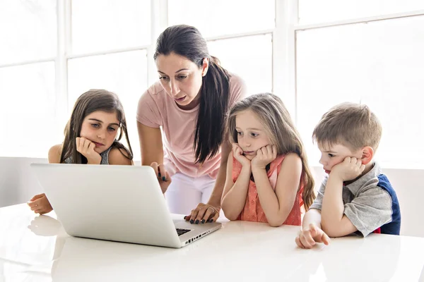 Nauczyciel z grupą dzieci w wieku szkolnym z laptopa z przodu — Zdjęcie stockowe